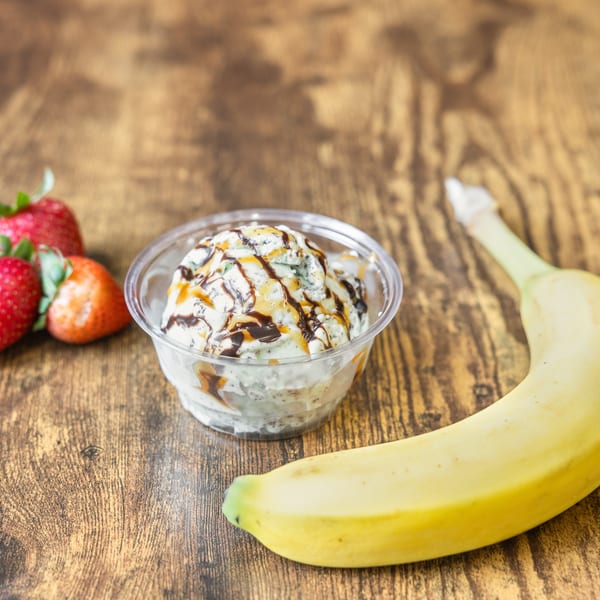 Mint chocolate chip ice cream with caramel and chocolate syrup, strawberries, and a banana.